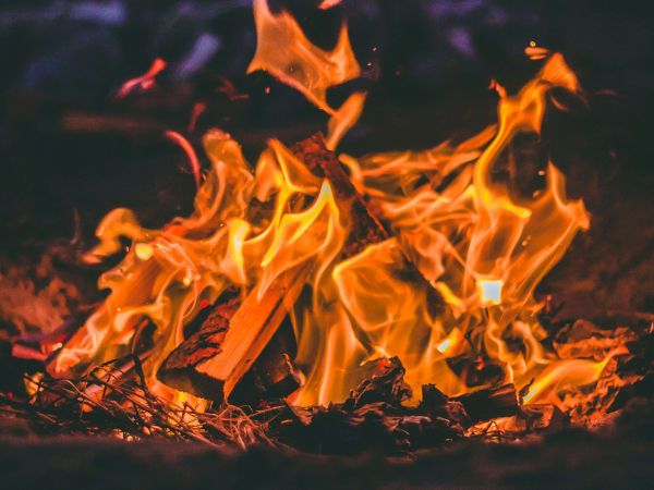 Auf schwarzem Hintergrund, ein Lagerfeuer mit lodernden Flammen.