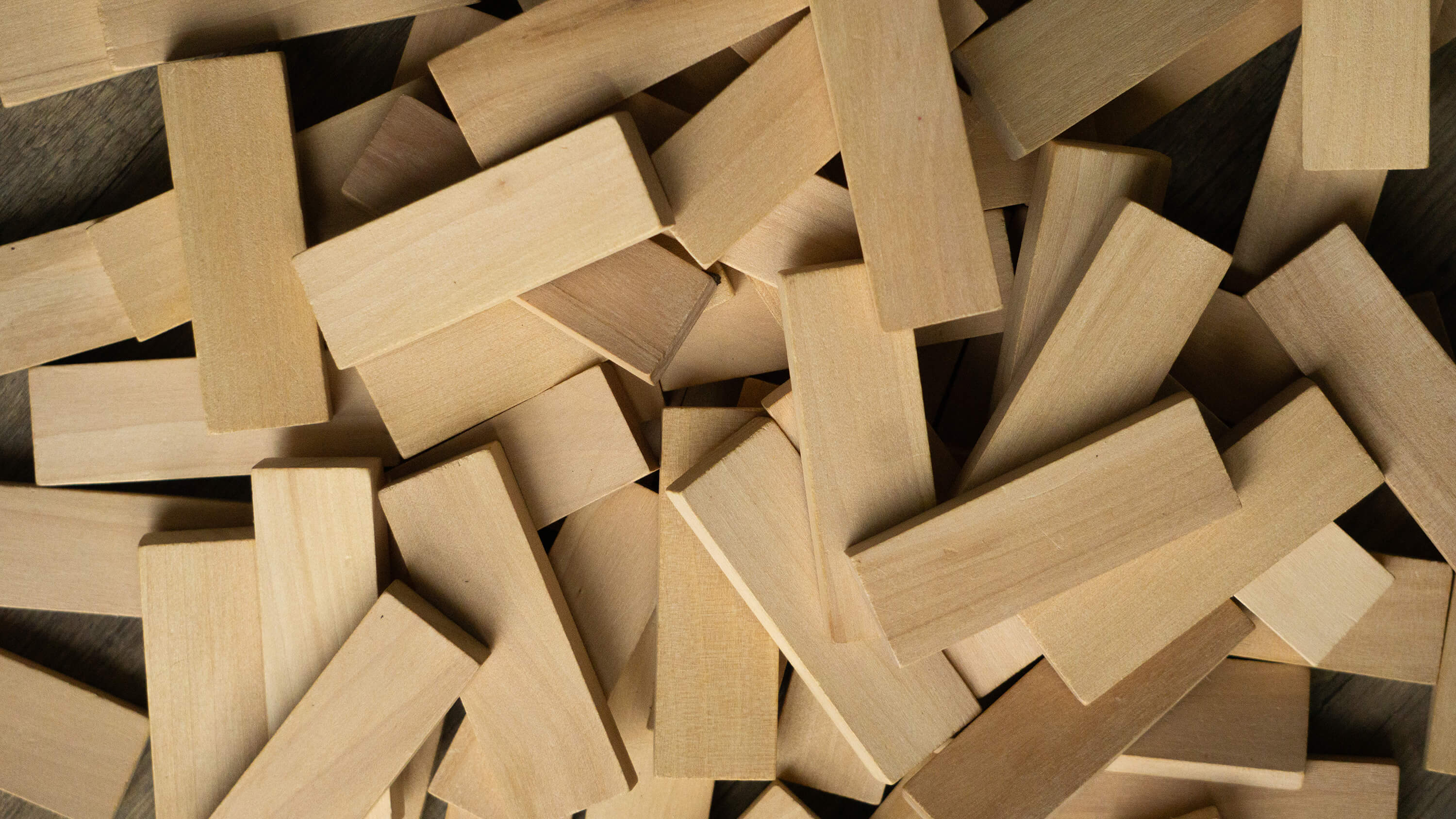 Viele Holzbausteine liegen auf einem Haufen.